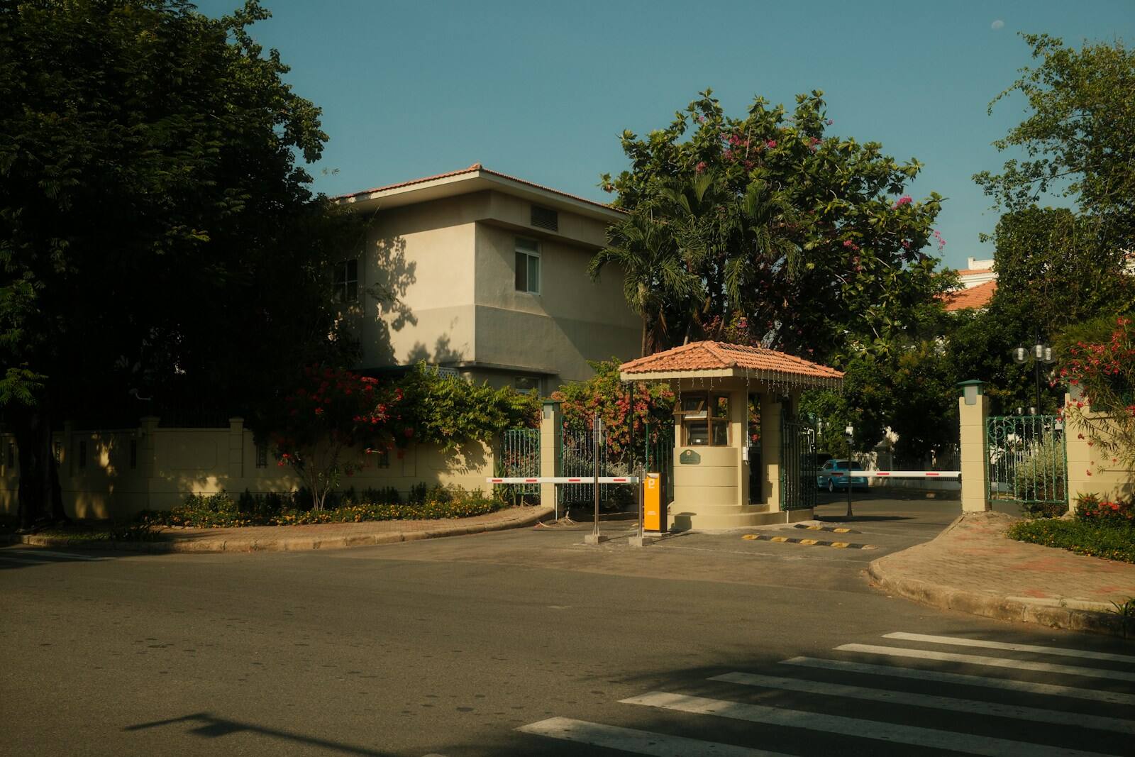 Calle arbolada de un barrio privado, vista desde el acceso